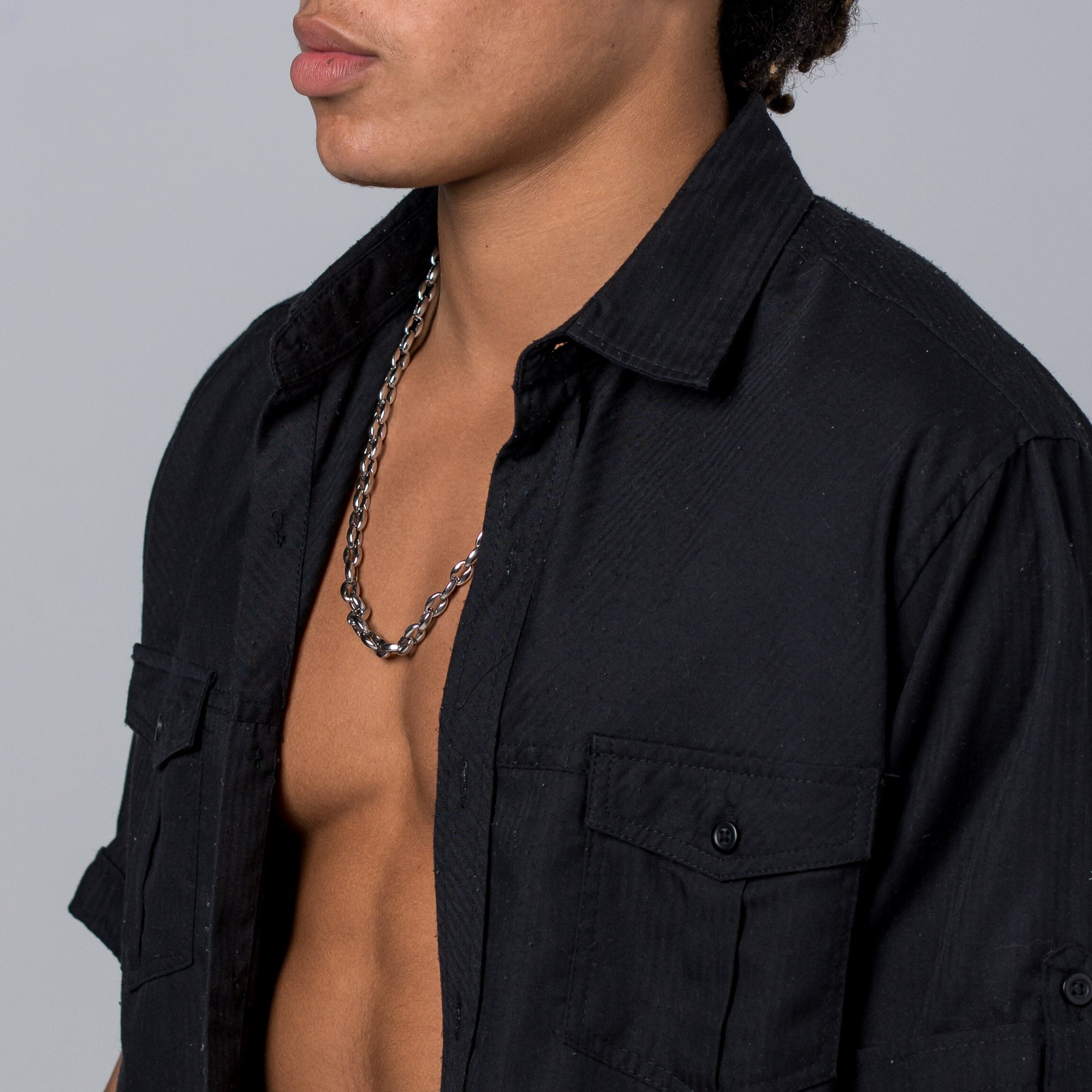 A silver Two Kxngs rope chain worn against skin under an open black shirt